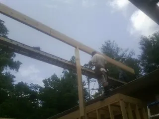 Carpenter setting a ridge beam over a new addition frame — Ice Dam Removal by Roofing Brothers in Ross